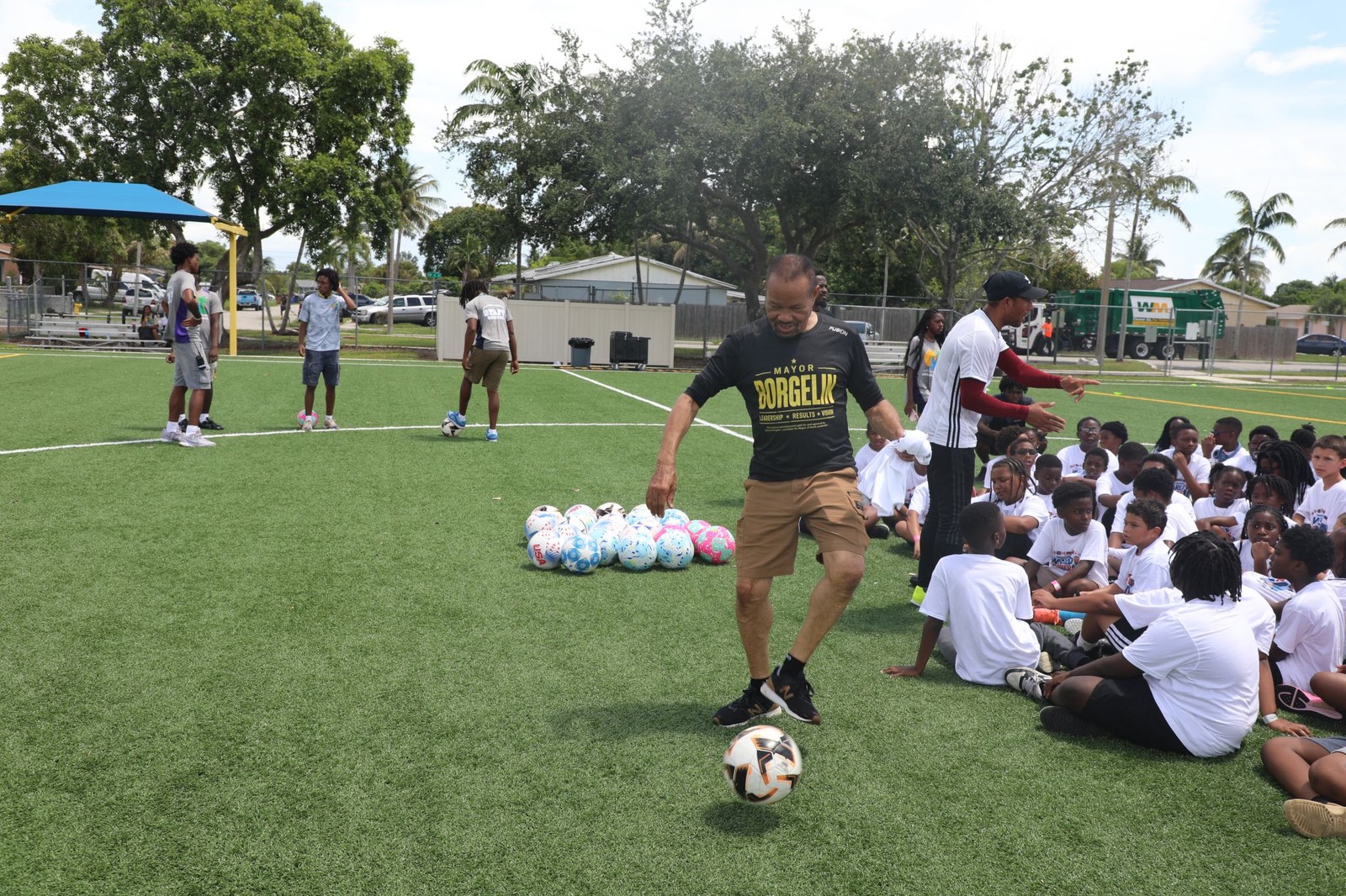 Mayor Borgelin plays soccer with young players at Highland Park